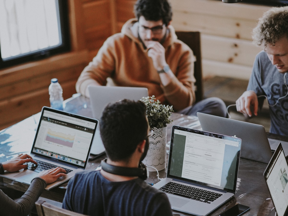 Team collaborating over laptops at a shared table